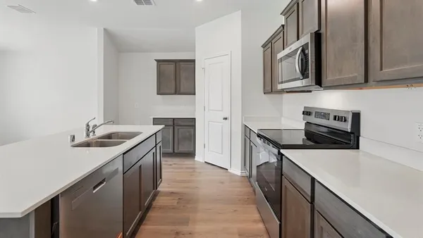 a kitchen with stainless steel appliances granite countertop a sink stove and refrigerator