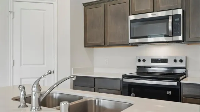 a kitchen with stainless steel appliances granite countertop a sink and a microwave