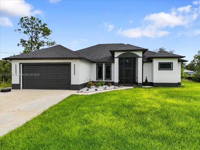 a front view of house with yard and garage