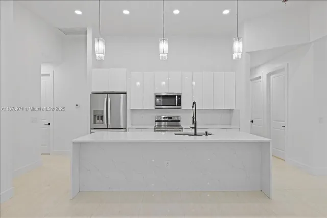 a large kitchen with kitchen island a sink stainless steel appliances and cabinets