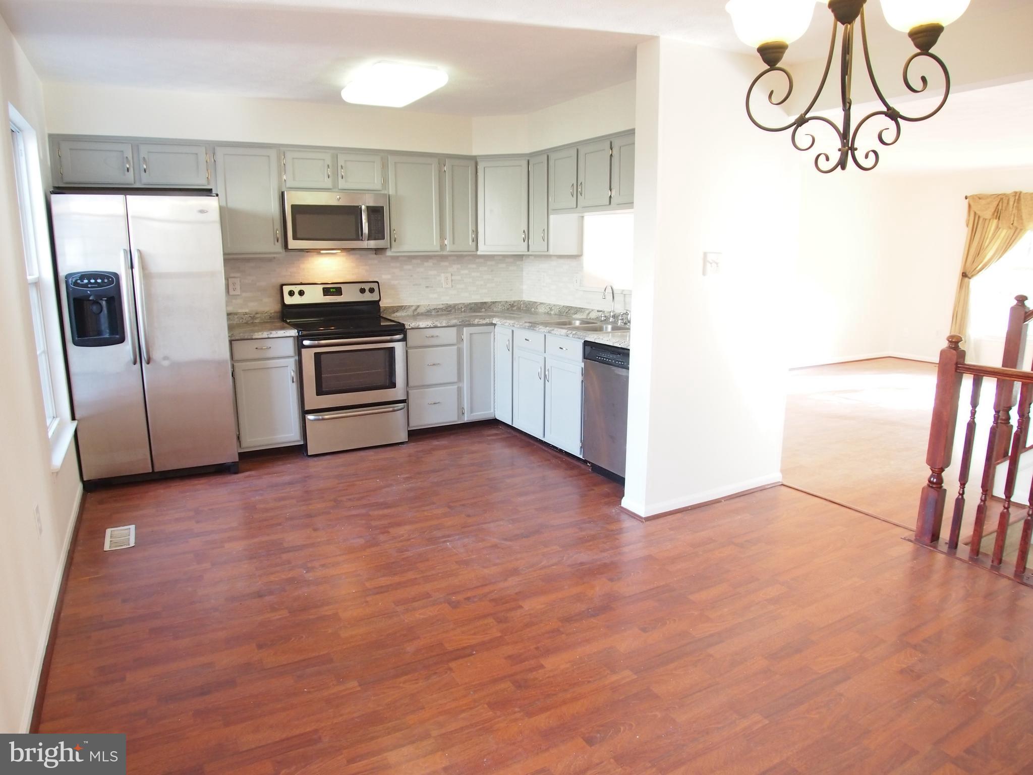 5307 Hollowstone Circle Rosedale, MD 21237 - Photo 7 of 22 a kitchen with a refrigerator and a stove top oven