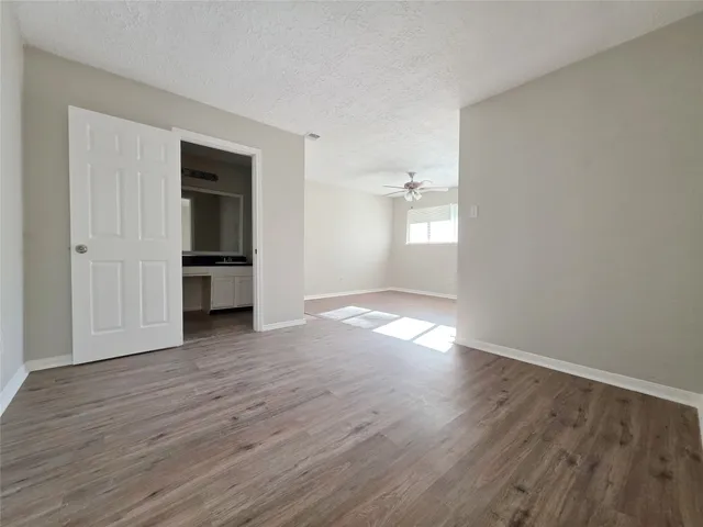 a view of empty room with wooden floor and window