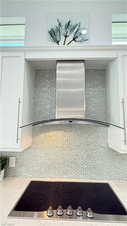 5060 Martinique Drive Naples, FL 34113 - Photo 21 of 49 Cool modern glass exhas hood covers the cooktop and enhances the glass tile backsplash