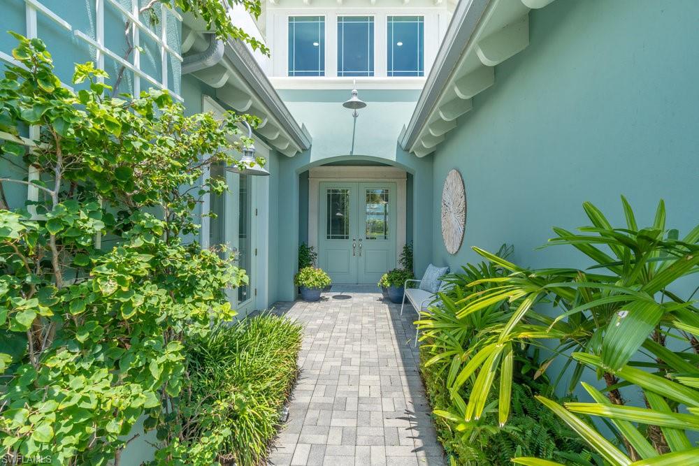 5060 Martinique Drive Naples, FL 34113 - Photo 7 of 49 lush vegetation with trellises of bougainvillea and planters of jasmine
