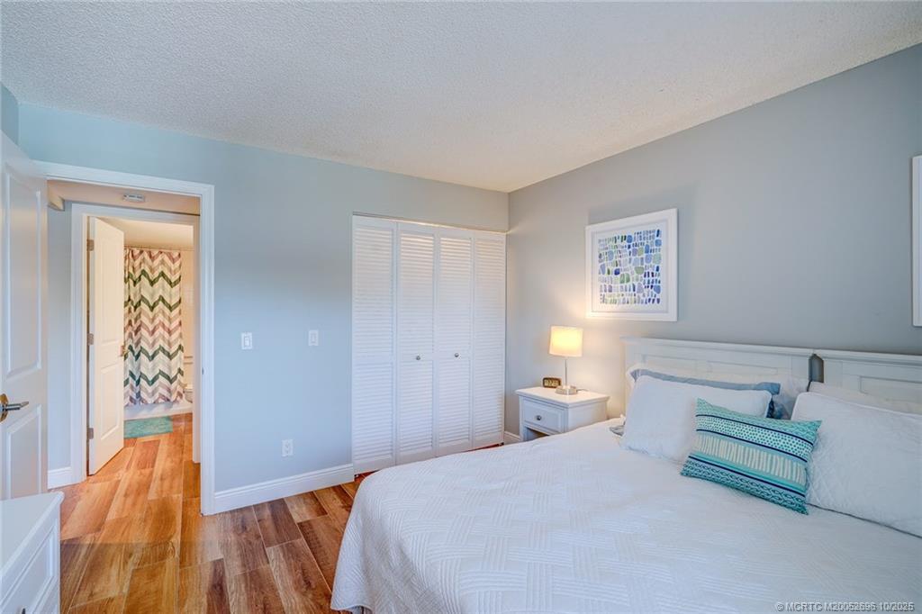 40 Northeast Plantation Road, Unit 203 Jensen Beach, FL 34957 - Photo 16 of 53 a bedroom with a bed and a lamp on the dresser