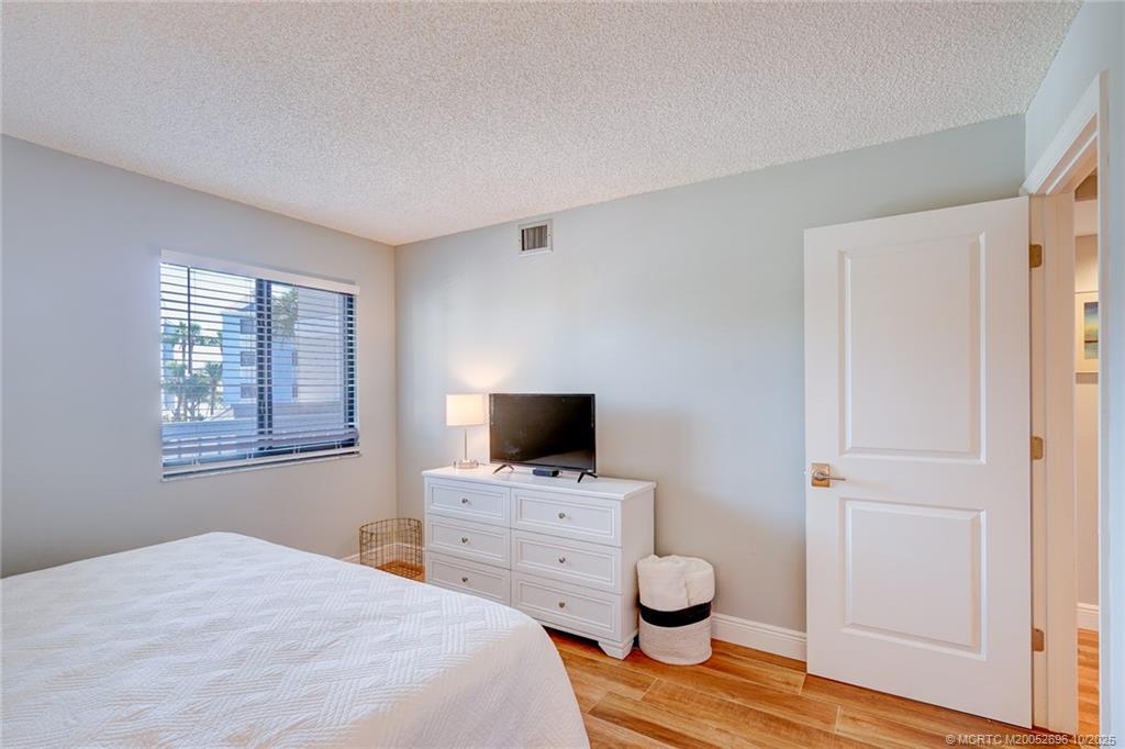 40 Northeast Plantation Road, Unit 203 Jensen Beach, FL 34957 - Photo 17 of 53 a bedroom with a bed and a flat screen tv