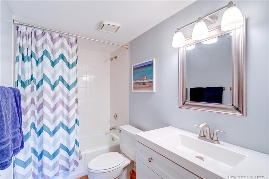 40 Northeast Plantation Road, Unit 203 Jensen Beach, FL 34957 - Photo 18 of 53 a bathroom with a sink a toilet and shower curtain