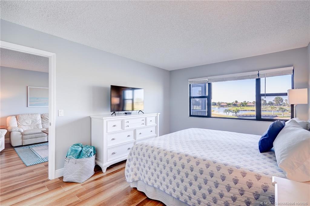 40 Northeast Plantation Road, Unit 203 Jensen Beach, FL 34957 - Photo 29 of 53 a bedroom with a bed and large windows