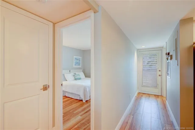 a hallway with wooden floor and bedroom view