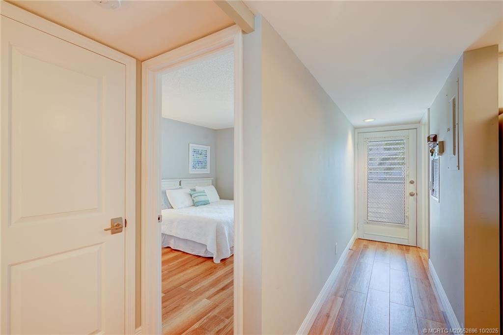 40 Northeast Plantation Road, Unit 203 Stuart, FL 34996 - Photo 3 of 8 a hallway with wooden floor and bedroom view