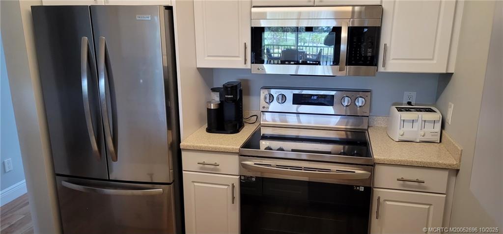 40 Northeast Plantation Road, Unit 203 Jensen Beach, FL 34957 - Photo 3 of 53 a kitchen with appliances and cabinets