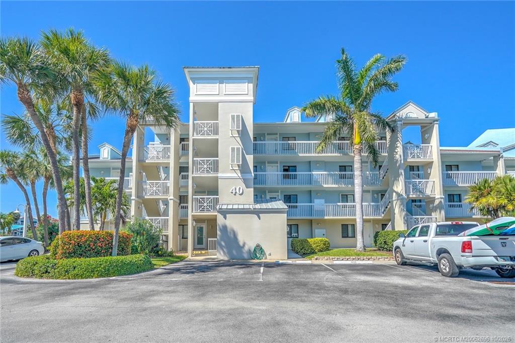 40 Northeast Plantation Road, Unit 203 Jensen Beach, FL 34957 - Photo 39 of 53 a front view of a building with a garden and plants
