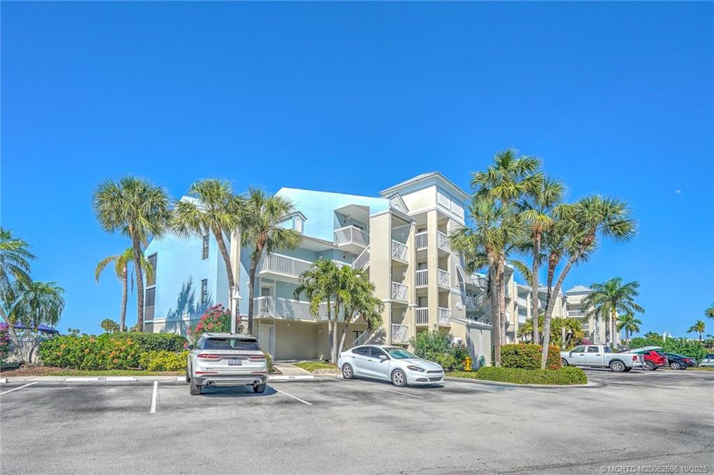40 Northeast Plantation Road, Unit 203 Jensen Beach, FL 34957 - Photo 40 of 53 a row of palm trees and sign board with buildings in the background