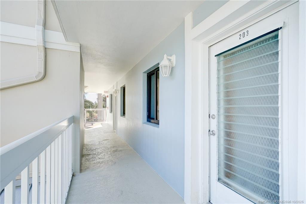 40 Northeast Plantation Road, Unit 203 Jensen Beach, FL 34957 - Photo 9 of 53 a view of a hallway with wooden floor and staircase