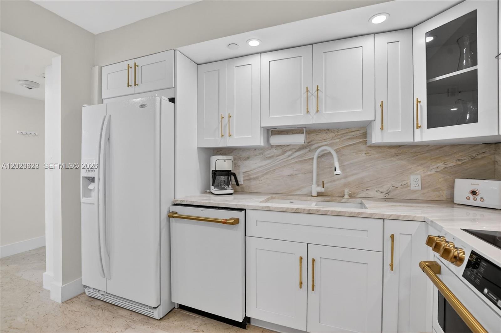 4101 North Ocean Boulevard, Unit 1605 Boca Raton, FL 33431 - Photo 3 of 35 a kitchen with white cabinets and sink