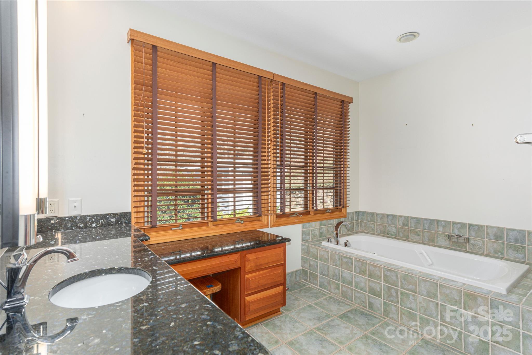 98 Flat Creek Road Fairview, NC 28730 - Photo 21 of 47 a bathroom with a granite countertop sink and a bathtub