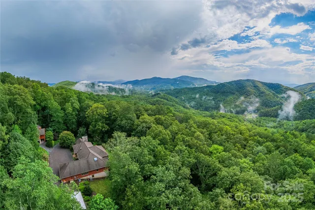 a view of an empty room with glass door and wooden floor