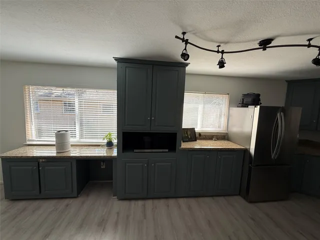 a kitchen with granite countertop a sink cabinets and wooden floor