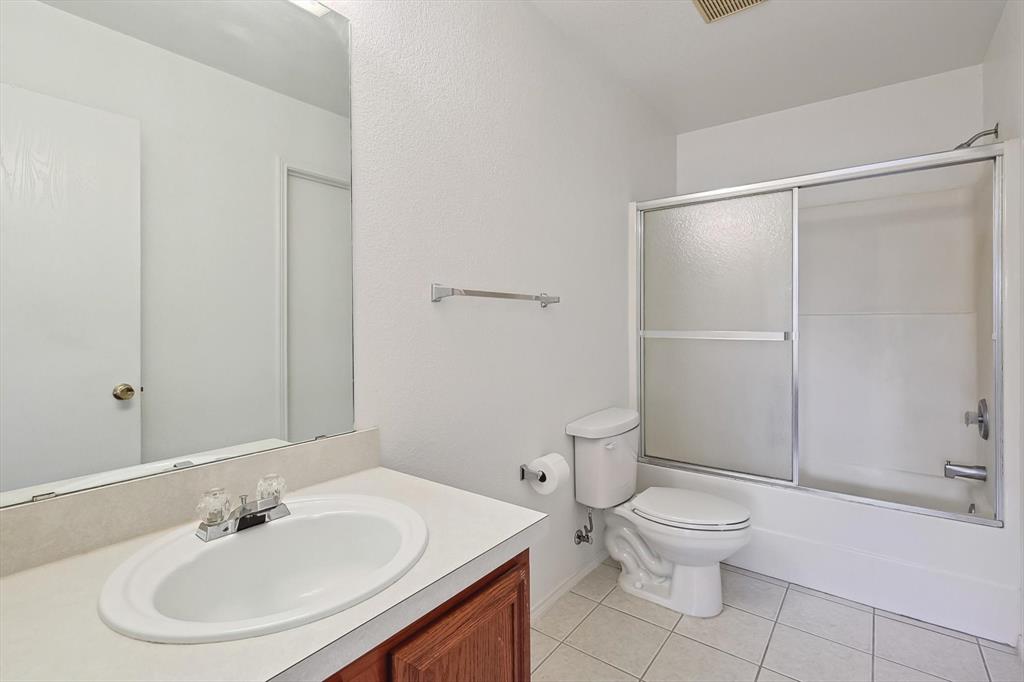 5424 Elk Ridge Drive Watauga, TX 76137 - Photo 21 of 40 a white toilet sitting next to a bathroom sink