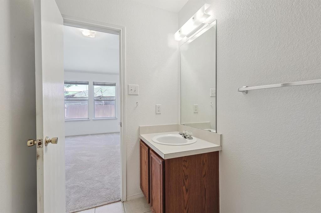 5424 Elk Ridge Drive Watauga, TX 76137 - Photo 23 of 40 a bathroom with a sink and mirror