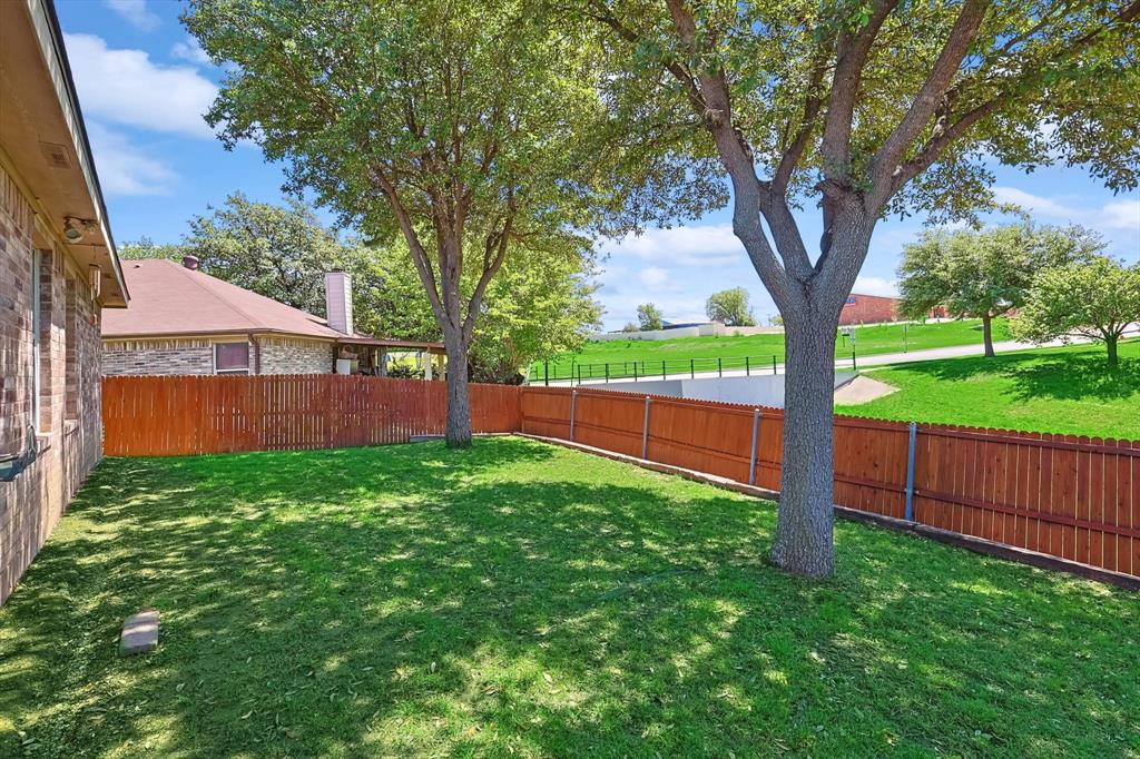 5424 Elk Ridge Drive Watauga, TX 76137 - Photo 31 of 40 a view of a yard with a tree and a fence