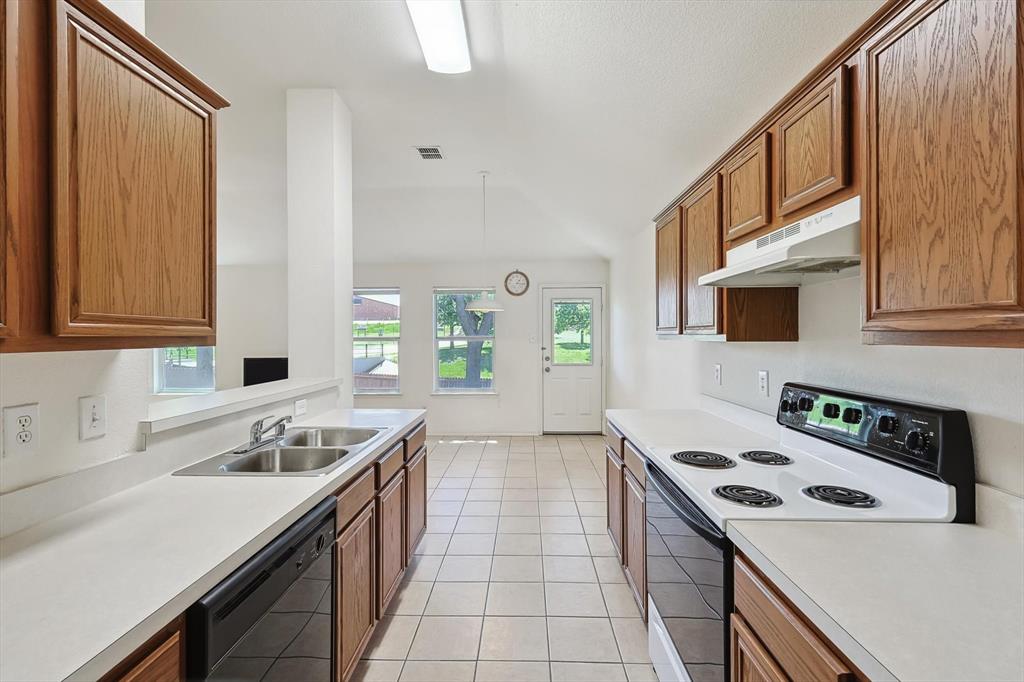 5424 Elk Ridge Drive Watauga, TX 76137 - Photo 8 of 40 a kitchen with a stove a sink and a refrigerator