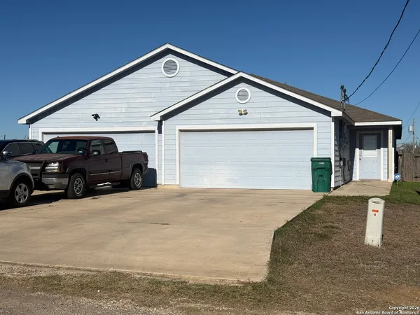 a front view of a house with cars parked