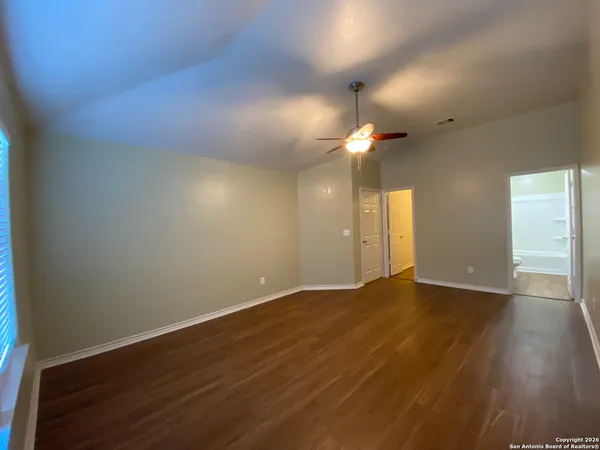 a view of an empty room with wooden floor