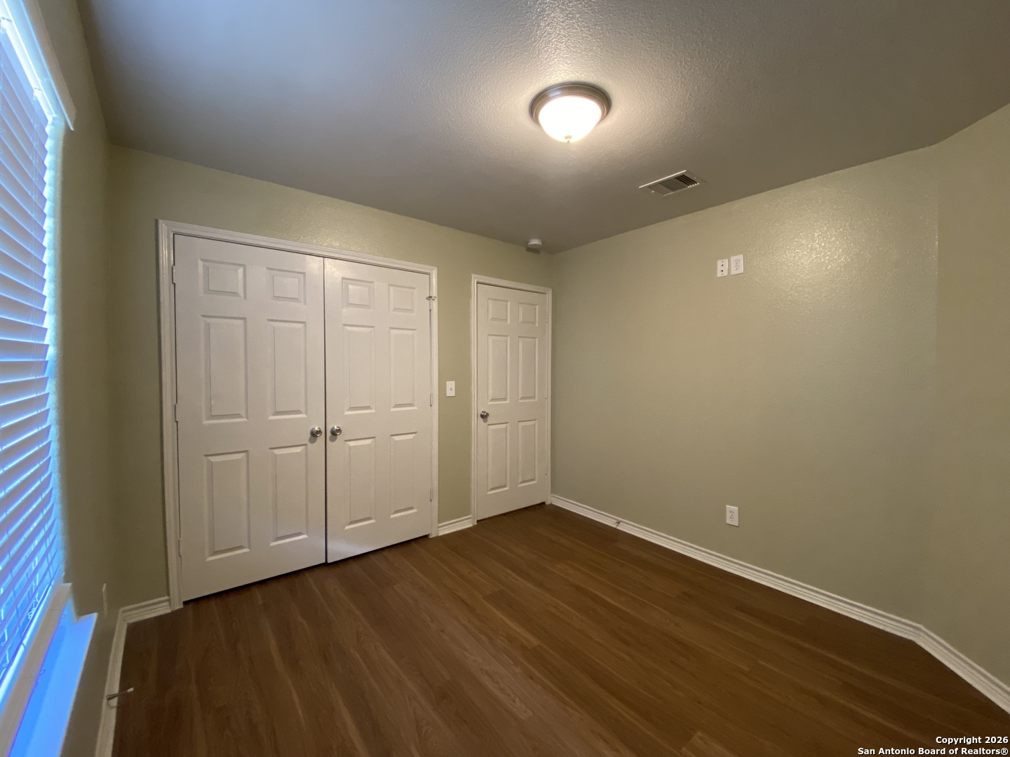 1103 Maple Street Jourdanton, TX 78026 - Photo 8 of 11 a view of an empty room with wooden floor and closet