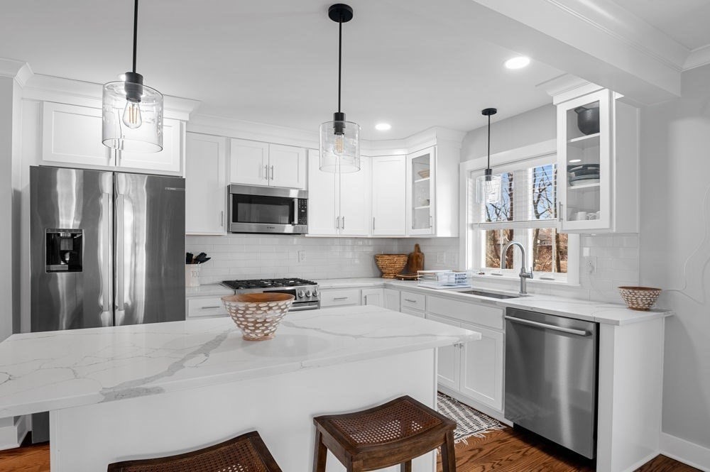 21 Hines Way, Unit 21 Newburyport, MA 01950 - Photo 4 of 21 a kitchen with stainless steel appliances granite countertop a refrigerator a sink dishwasher a stove and white cabinets with wooden floor