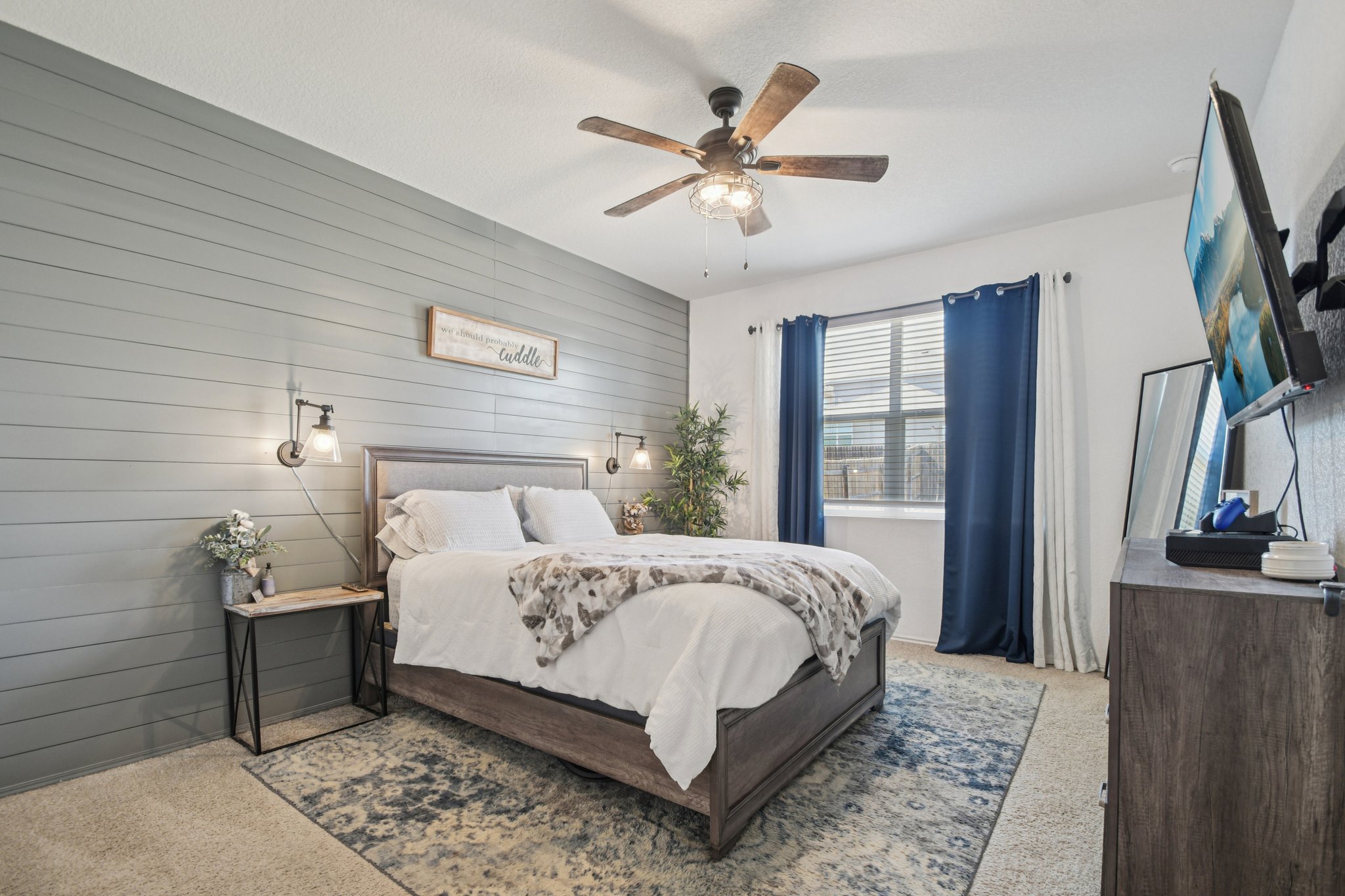 14904 Shalestone Way Manor, TX 78653 - Photo 9 of 23 Primary bedroom featuring carpet, wood walls, and a ceiling fan