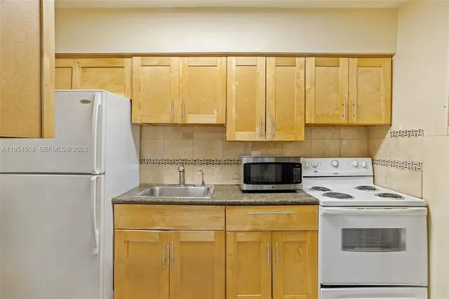a kitchen with a refrigerator sink stove and cabinets