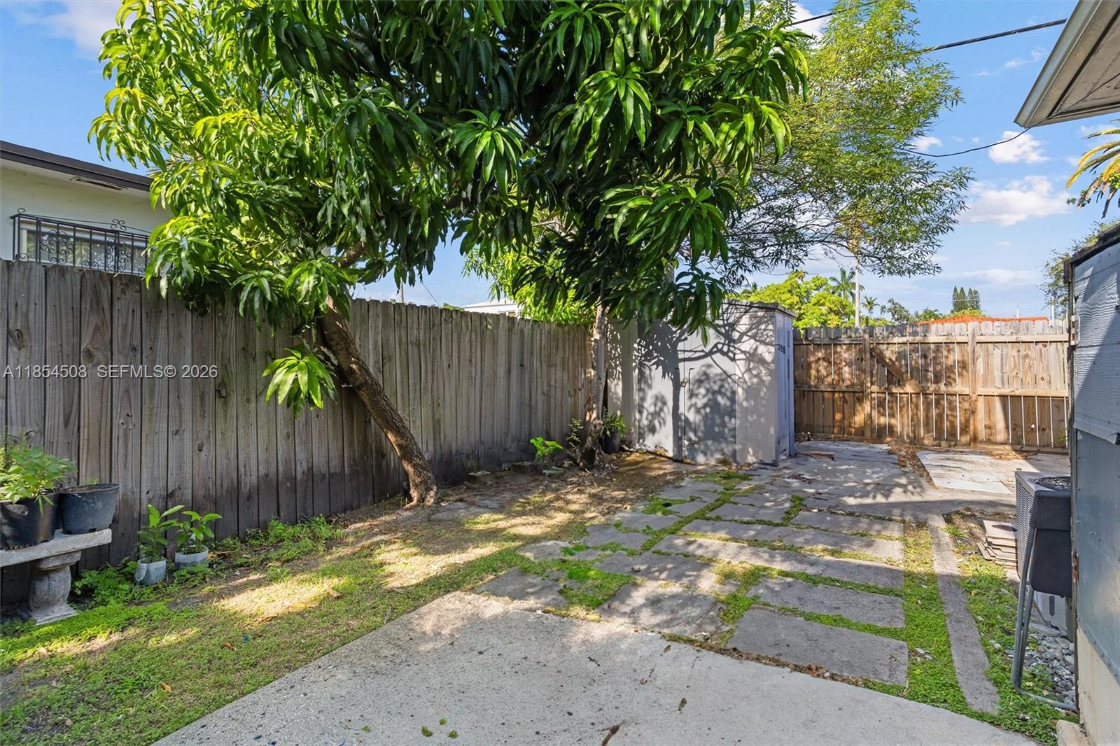 1701 Southwest 21st Street Miami, FL 33145 - Photo 25 of 28 a backyard of a house with table and chairs a barbeque with wooden fence