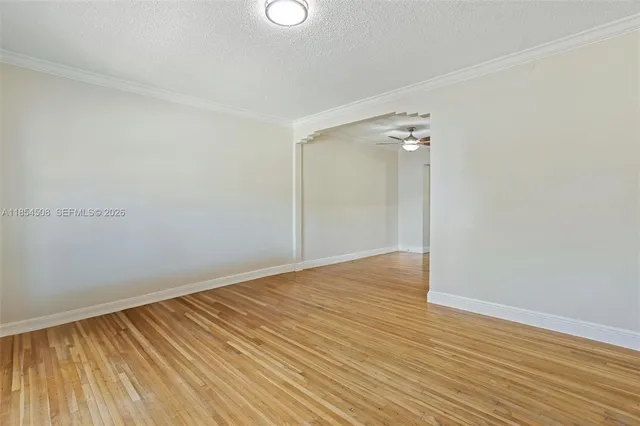 a view of an empty room with wooden floor