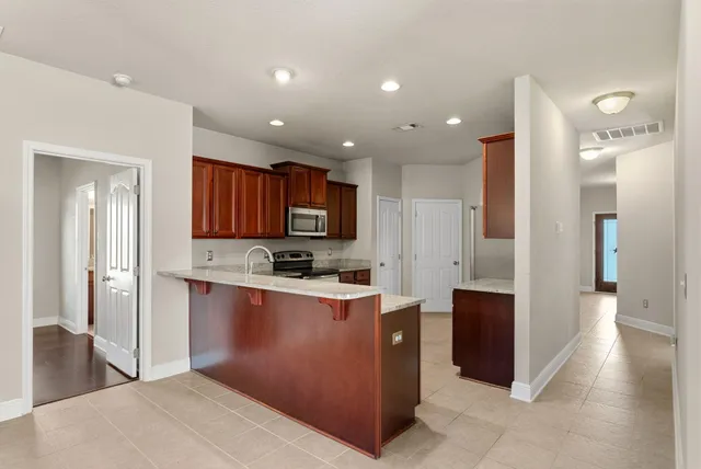a kitchen with stainless steel appliances granite countertop a sink stove and microwave