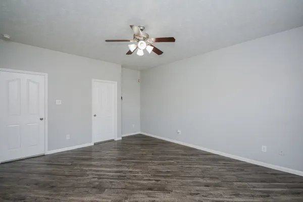 a view of an empty room with wooden floor