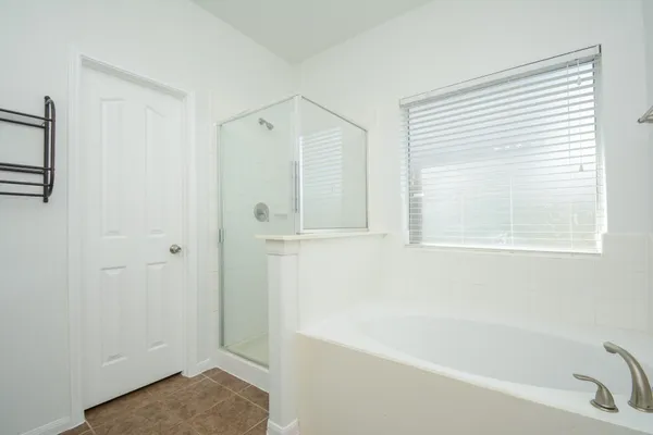 a bathroom with a tub shower and a window