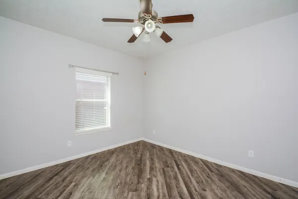 an empty room with a window and a fan