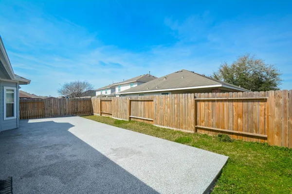a view of a back yard with wooden fence