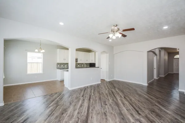 a view of a kitchen with wooden floor and a ceiling fan