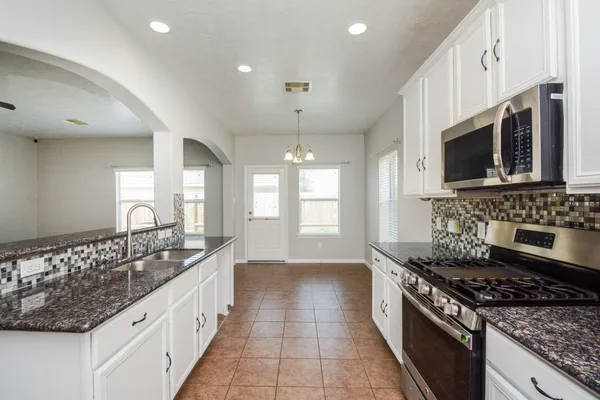 a kitchen with stainless steel appliances granite countertop a sink stove and cabinets