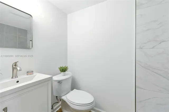 a bathroom with a sink a toilet and mirror