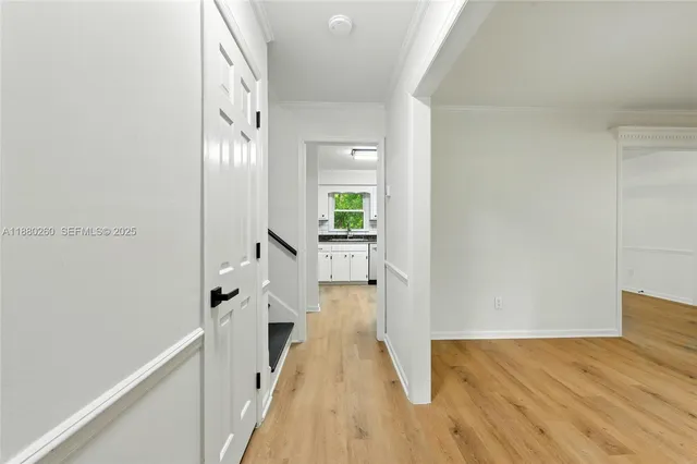 a view of a hallway with wooden floor and staircase