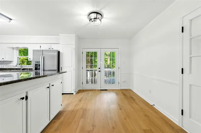 a view of a kitchen with wooden floor and a window