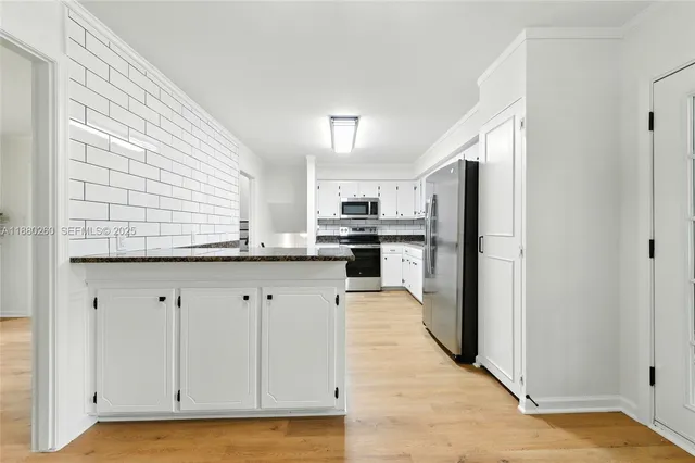 a kitchen with stainless steel appliances granite countertop a refrigerator and a stove