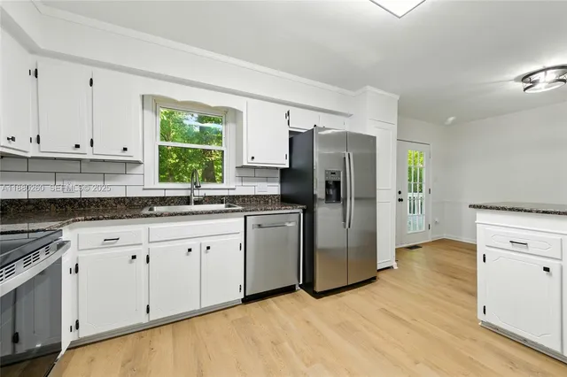 a kitchen with a refrigerator sink and cabinets