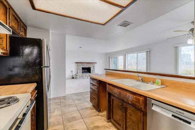 a kitchen with stainless steel appliances granite countertop a refrigerator and a stove top oven