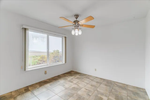 a view of an livingroom with a window and a kitchen