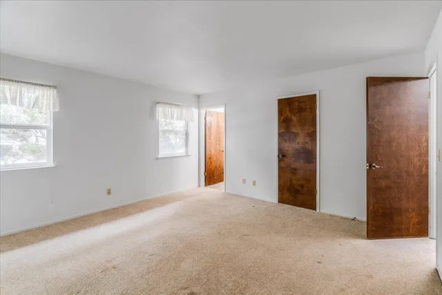 a view of an empty room with closet and bathroom