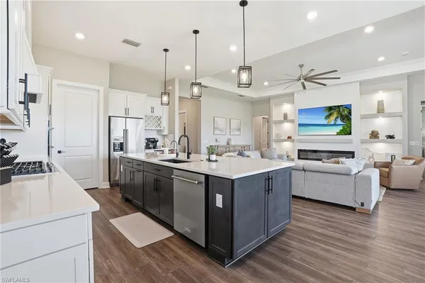 a large kitchen with stainless steel appliances kitchen island granite countertop a lot of cabinets and wooden floor